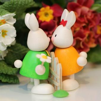 Hobler Osterhase Kaninchen Max und Emma küssend am Gartenzaun 